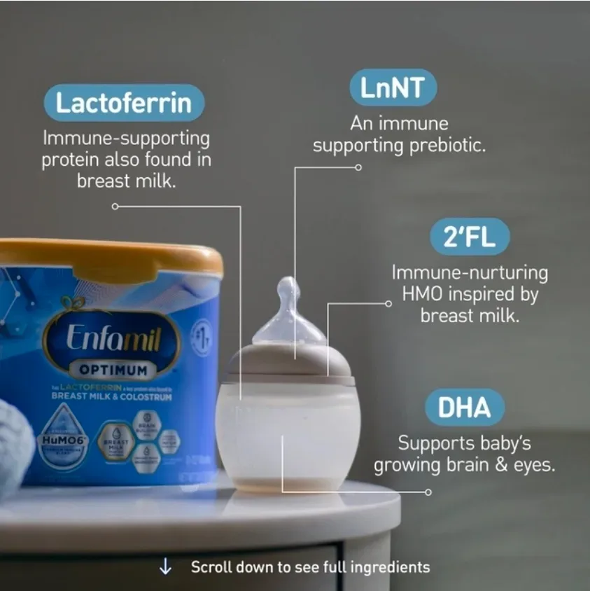 Enfamil Optimum powder formula scoop next to a prepared baby bottle on a wooden surface.